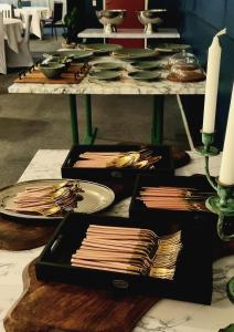 エスキルストゥーナにあるHotell Tre Systrarの皿数皿とキャンドルが並ぶテーブル