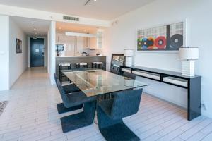 comedor con mesa de cristal y sillas en Oceanfront Private Residence at W South Beach -828, en Miami Beach