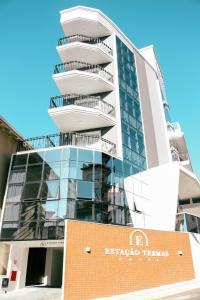 a tall building with a sign in front of it at Estação Termas Hotel in Piratuba