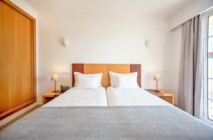 a bedroom with a large bed with two white pillows at Aquamar Albufeira Aparthotel in Albufeira