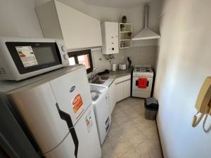 uma pequena cozinha com um micro-ondas em cima de um frigorífico em SUPER UBICACIÓN NUEVA CÓRDOBA em Córdoba