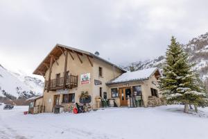 a large building in the snow with a christmas tree at REFUGE- GITE Le Pas de l'Ane in Villar-dʼArène
