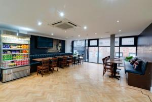 a restaurant with a bar and tables and chairs at The Podworks Hotel in Liverpool