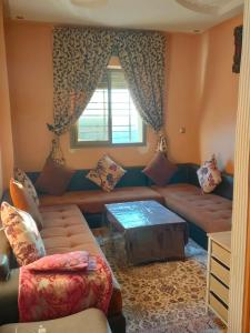 - un salon avec un canapé et une table dans l'établissement Appartement wifaq, à Temara