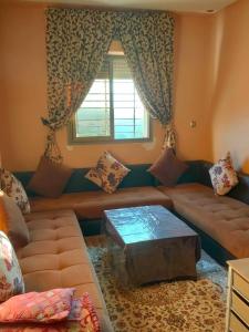 ein Wohnzimmer mit einem Sofa und einem Fenster in der Unterkunft Appartement wifaq in Temara