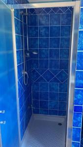 a blue tiled shower with a blue tiled wall at La casa di Nettuno in Naples