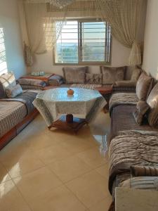 a living room with couches and a table at Appartement wifaq in Temara