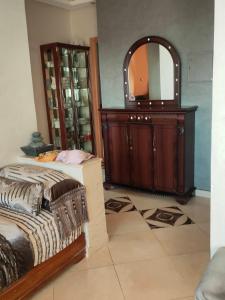 Schlafzimmer mit einem Bett, einer Kommode und einem Spiegel in der Unterkunft Appartement wifaq in Temara