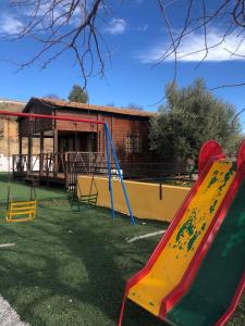 a playground with two slides in a yard at Casa Los Bartolos in Vélez-Rubio