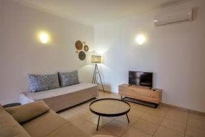 a living room with a couch and a tv at Aquamar Albufeira Aparthotel in Albufeira