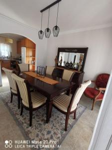 a dining room with a wooden table and chairs at Villa Lala in Amoreira +17 photos