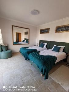 a bedroom with three beds and a mirror at Villa Lala in Amoreira