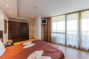 1 dormitorio con cama grande y ventana grande en Marina CITY SEA VIEW APARTAMENT en Balchik