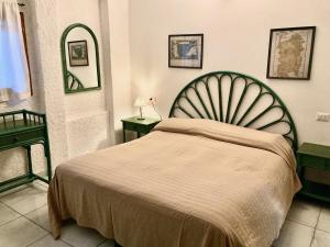 サンタ・テレーザ・ガッルーラにあるVilla Angelaのベッドルーム1室(ベッド1台、テーブル2台、鏡付)