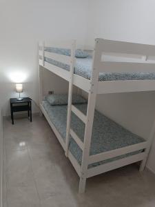 Casa degli Ulivi con parcheggio privato في Muro Lucano: سريرين بطابقين في غرفة مع مصباح