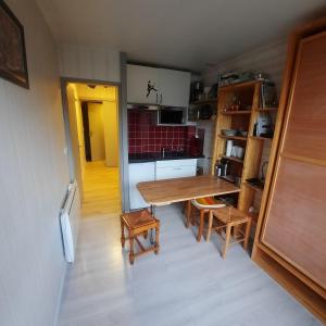 a small kitchen with a wooden table and chairs at Studio pied des pistes saint lary in Saint-Lary-Soulan