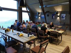 un grupo de personas sentadas en mesas en un restaurante en BaseCamp Vega, en Sundsvoll