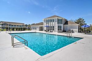 - une piscine en face d'une maison dans l'établissement Bright Gulf Shores Condo - 5 Mi to Beach!, à Gulf Shores