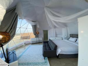 a bedroom with a bed and a couch and a large window at Turquoise Resorts in Ar Ruways