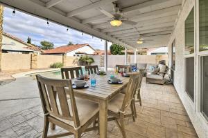 een patio met een houten tafel en stoelen bij Updated Gilbert Home with Pool, Outdoor Dining Area in Gilbert