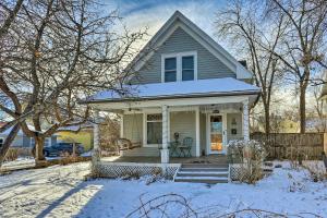a white house with a porch in the snow at Chic Rapid City Escape Near Mount Rushmore! in Rapid City