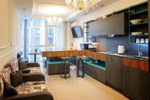 a living room with a kitchen with a counter and chairs at Sun apartments in Kyiv