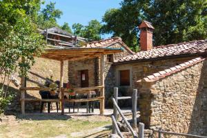 a small stone house with a table and a porch at Agriturismo con piscina in Toscana, Tribbiano in Arezzo