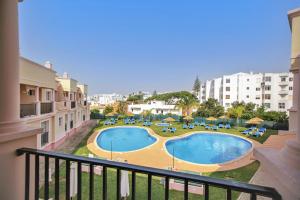 a view of a swimming pool from a balcony of a building at Aquamar Albufeira Aparthotel in Albufeira