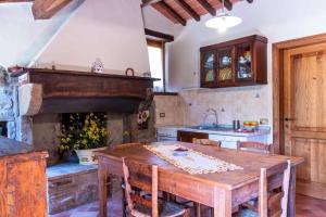 a kitchen with a wooden table and a fireplace at Agriturismo con piscina in Toscana, Tribbiano in Arezzo