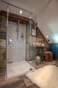 a bathroom with a glass shower with a sink at The Lodge in the Loch in Portree