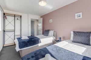 Kirby MuxloeにあるSpacious and Comfortable Home near Fosse Parkのベッドルーム1室(ベッド2台、クローゼット付)