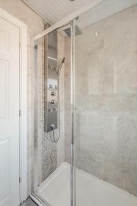a shower with a glass door in a bathroom at Spacious and Comfortable Home near Fosse Park in Kirby Muxloe