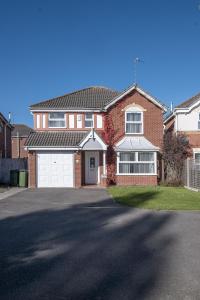 a large brick house with a white garage at Spacious and Comfortable Home near Fosse Park in Kirby Muxloe