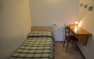 a small room with a bed and a desk at Casa al Portico in Ledro