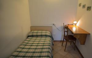 レードロにあるCasa al Porticoのベッドとデスクが備わる小さな客室です。