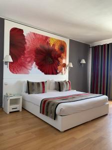 a bedroom with a bed with a flower painting on the wall at One Resort Jockey Monastir in Monastir +56 photos