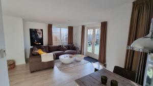 un soggiorno con divano e tavolo di Recreatiewoning Maas en Waal 191 a Ewijk