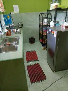 uma cozinha com lavatório e tapetes vermelhos no chão em HOMESTAY JANNATI TAMBUN em Tambun