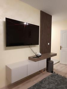 a living room with a tv on a wall at Apartament Tzar Kaloyan in Burgas