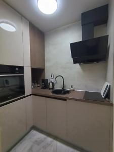 a small kitchen with a sink and a stove at Apartament Tzar Kaloyan in Burgas