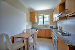 a small kitchen with a table and chairs and a sink at Aquamar Albufeira Aparthotel in Albufeira