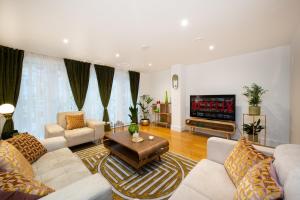 a living room with white furniture and a flat screen tv at London Nino Apartments in London