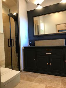 a bathroom with a black vanity and a mirror at Maison Villa Provence Villeneuve les Avignon piscine vue Mont Ventoux in Villeneuve-lès-Avignon