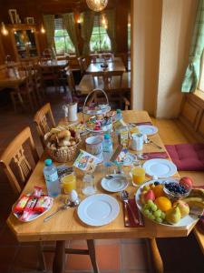 una mesa de madera con platos de comida y fruta. en Air Muc Park Sleep & Fly, en Hallbergmoos