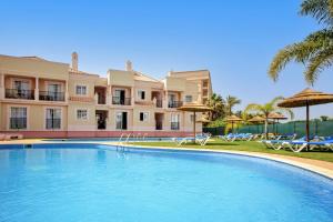 a large swimming pool in front of a building at Aquamar Albufeira Aparthotel in Albufeira
