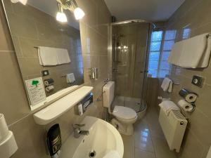 La salle de bains est pourvue d'un lavabo, de toilettes et d'une douche. dans l'établissement Hafner Hotel- Apartment, à Stuttgart