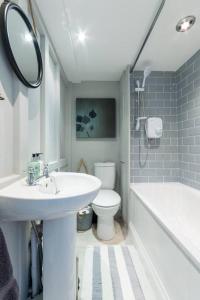 a bathroom with a sink and a toilet and a mirror at Talliers Cottage - Characterful & Central in Cirencester
