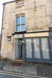 a brick building with a blue door and a window at Talliers Cottage - Characterful & Central in Cirencester