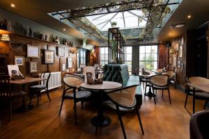 a restaurant with tables and chairs and a window at The Angel Inn - The Inn Collection Group in Bowness-on-Windermere