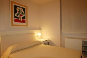ein Schlafzimmer mit einem Bett und einem Bild an der Wand in der Unterkunft Rosa dels Vents in L'Ampolla